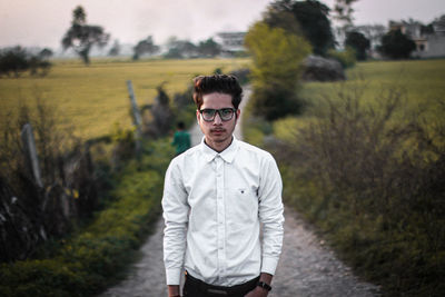 Portrait of young man standing on field