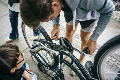 High angle view of man repairing bicycle on street