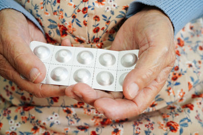 Cropped hand of woman holding blister pack