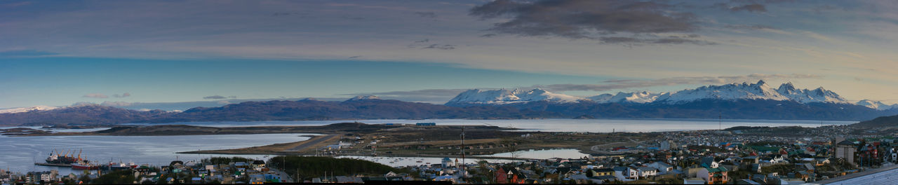 Panoramic shot of crowd by sea against sky