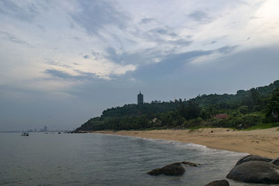 Scenic view of sea by buildings against sky