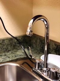 Close-up of faucet in bathroom at home