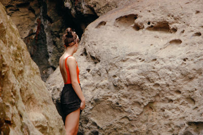 Side view of woman standing on rock