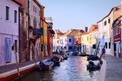 Boats in canal amidst buildings in city