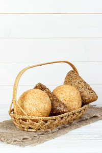 Close-up of bread in basket on table against white background