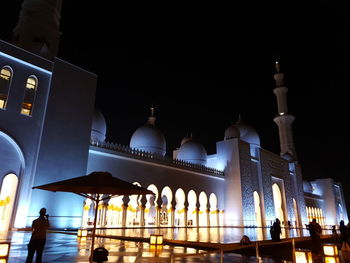 Illuminated building against clear sky at night