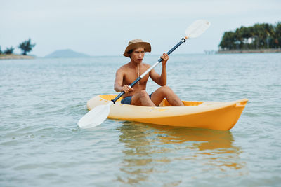 Man kayaking in sea