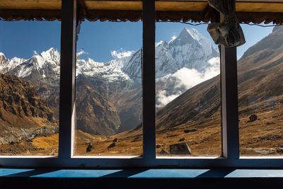 Snow covered landscape seen through window