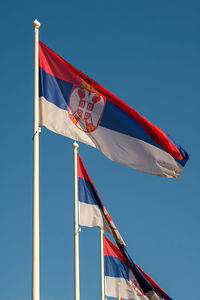 Low angle view of flag flags against sky