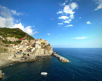 Scenic view of sea by buildings against sky