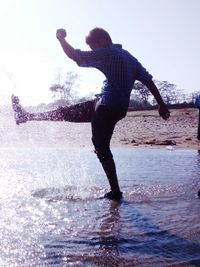 Full length of woman jumping in water