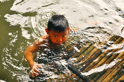 High angle portrait of boy swimming in lake