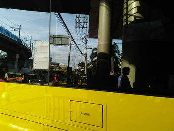 Yellow car on city street against sky