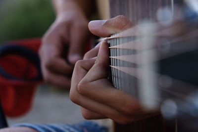 Cropped hand of man playing guitar