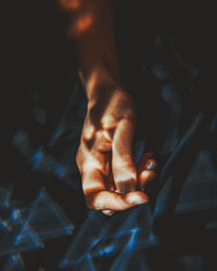 Close-up of person hand on bed