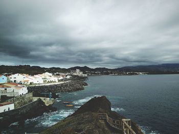 High angle view of town by sea against sky