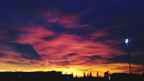 Low angle view of silhouette buildings against sky at sunset