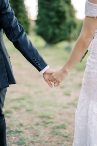 Low section of couple holding hands