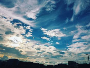 Low angle view of buildings against cloudy sky