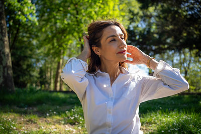 Young woman drinking water while standing outdoors
