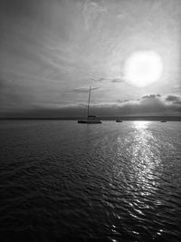 Sailboat sailing on sea against sky during sunset