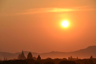 Scenic view of silhouette mountains against orange sky