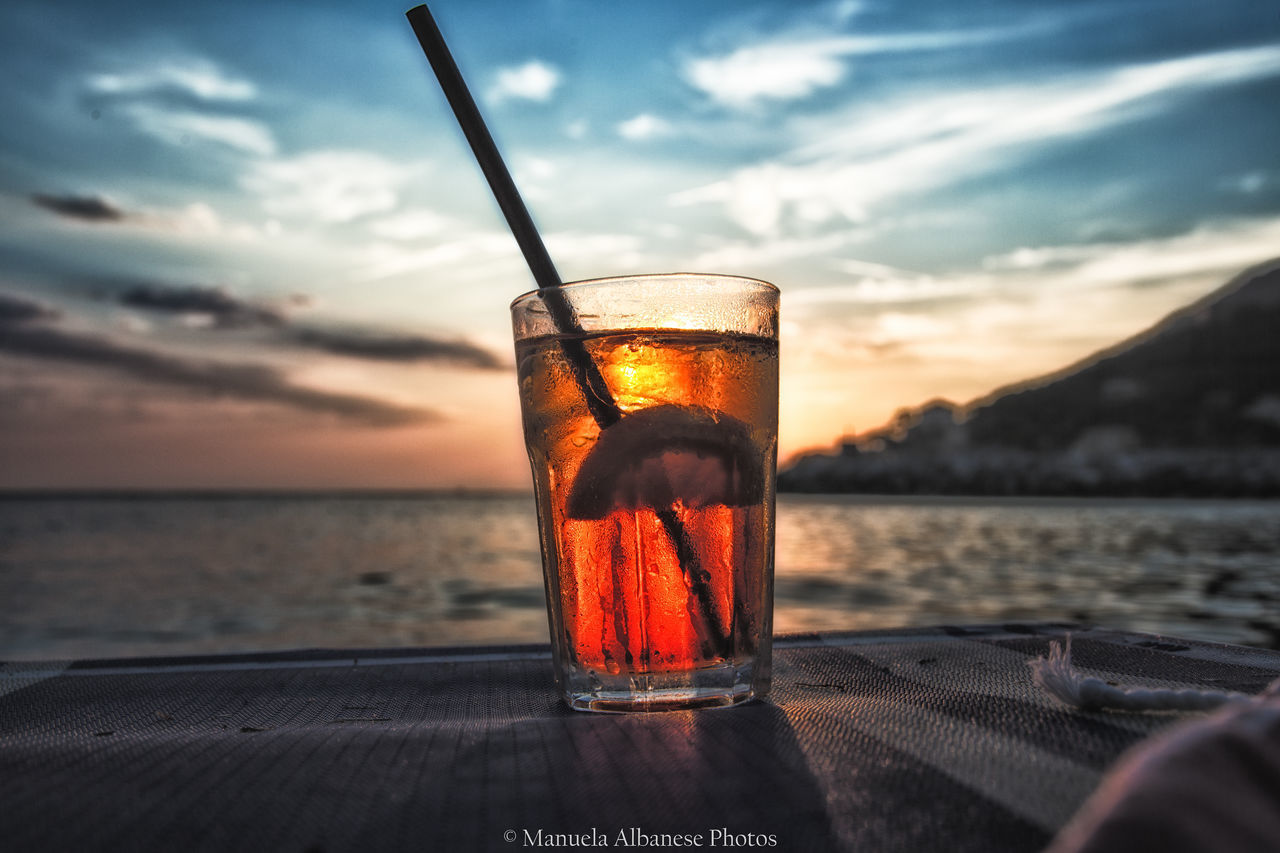 GLASS OF WATER AGAINST SKY DURING SUNSET