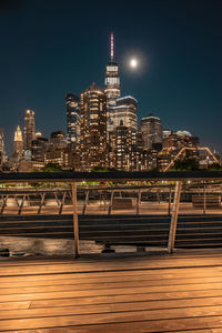 Illuminated buildings in city against sky at night