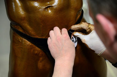 Midsection of man labeling bodybuilder