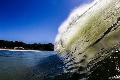 Sea waves splashing against blue sky