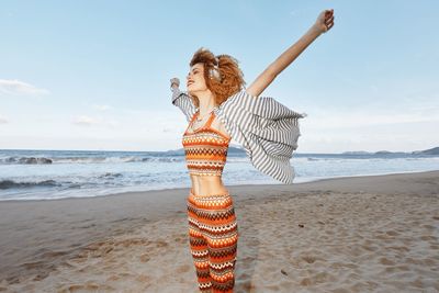 Side view of woman standing at beach