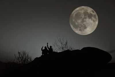 Low angle view of silhouette man standing against sky at night