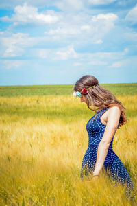 Side view of young woman standing in field