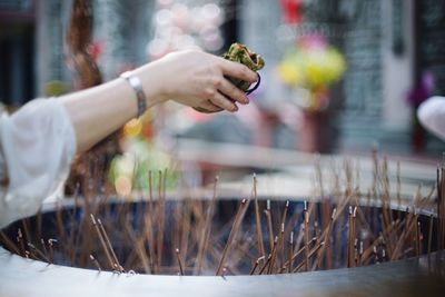 Cropped image of hand praying over incense