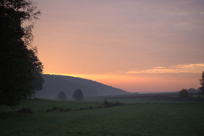 Scenic view of field against sky during sunset