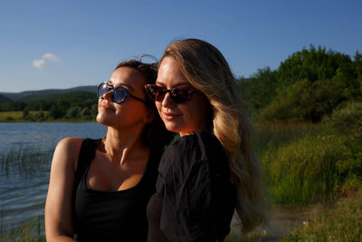Portrait of beautiful women wearing sunglasses against sky
