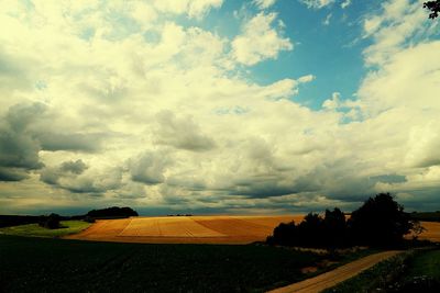 Scenic view of field against cloudy sky