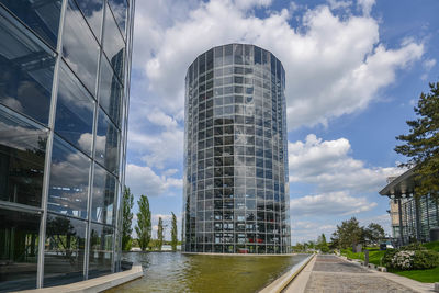 Road by modern buildings against sky in city