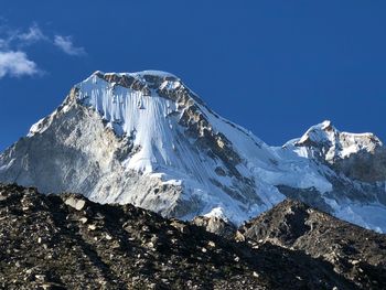 Scenic view of snowcapped mountains against blue sky