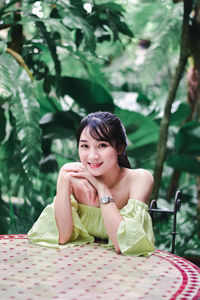 Portrait of a smiling young woman sitting outdoors