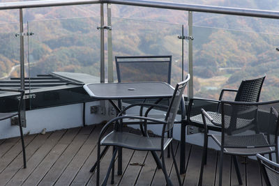 Empty chairs and tables in glass window