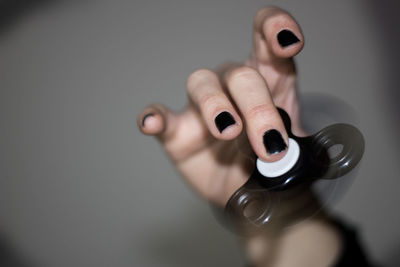 Close-up of woman holding hands against gray background