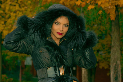 Portrait of young woman against tree