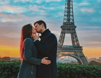 Young couple standing against tower