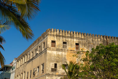 Low angle view of building against clear blue sky