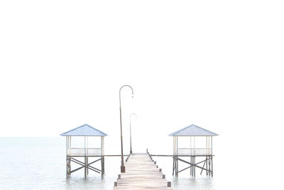 Lifeguard hut on pier against clear sky