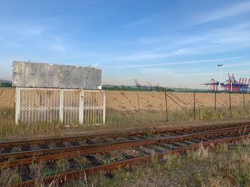 Railroad tracks on field against sky