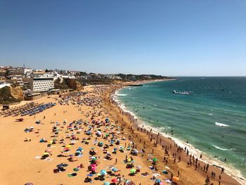 High angle view of people on beach against clear sky