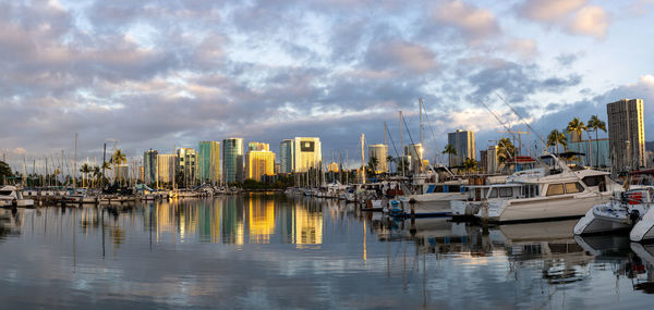 Honolulu skyline reflected in the marina harbor at sunrise