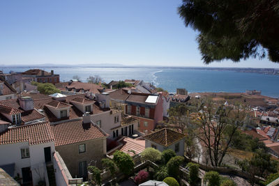 High angle view of townscape by sea against sky